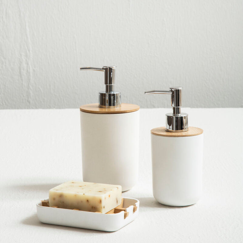 Two white soap dispensers with wooden accents on a light surface.