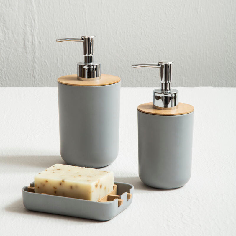 Two gray soap dispensers with wooden accents on a white surface.