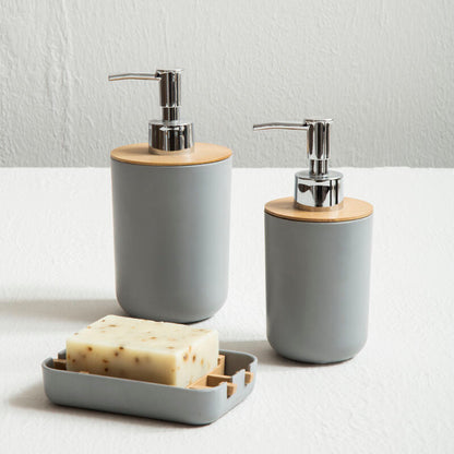 Two gray soap dispensers with wooden accents on a white surface.