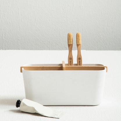 White container with wooden utensils on a light gray background