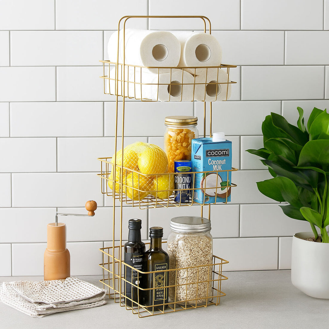 Gold wire rack with kitchen items against a white tiled wall