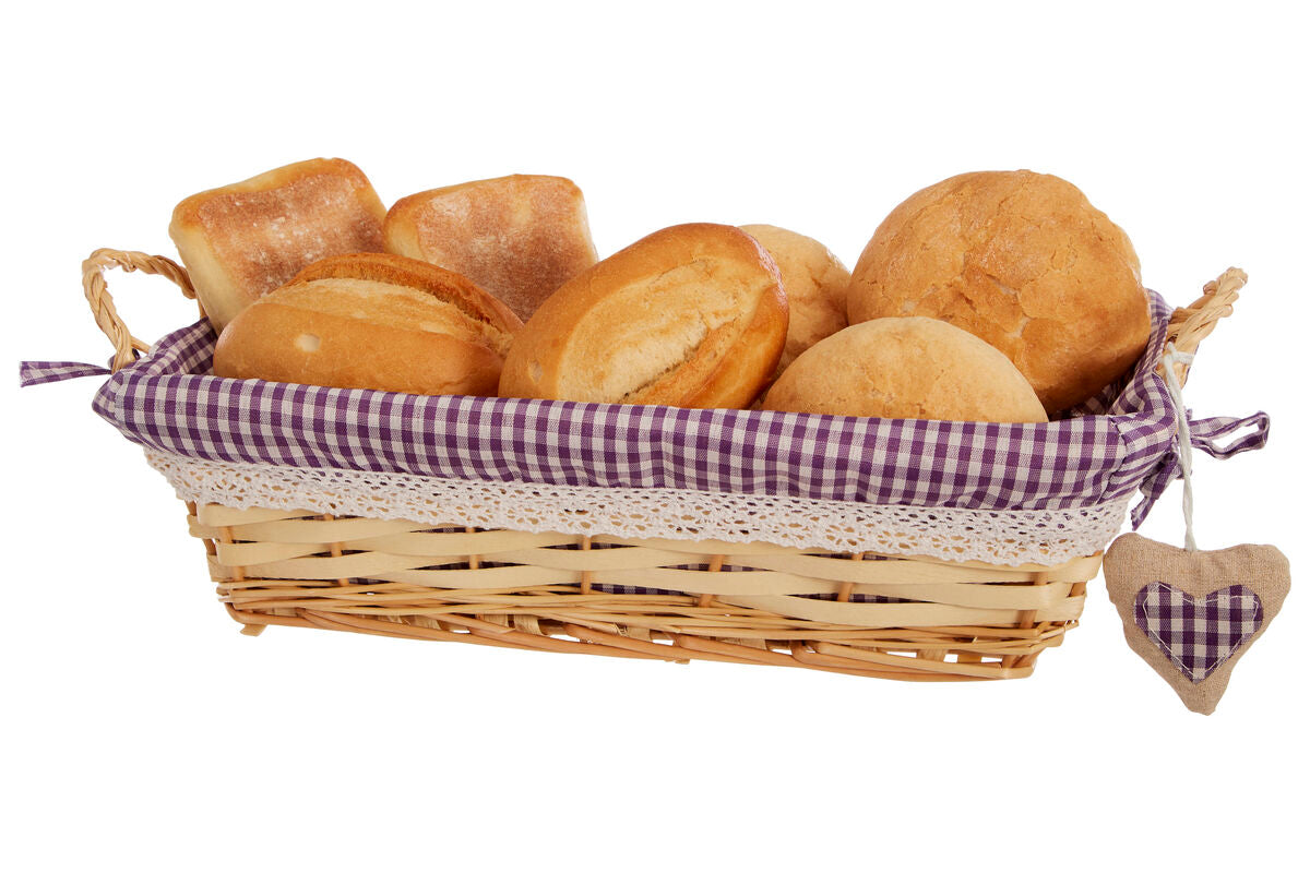 Wicker basket with checkered lining filled with bread rolls on a white background