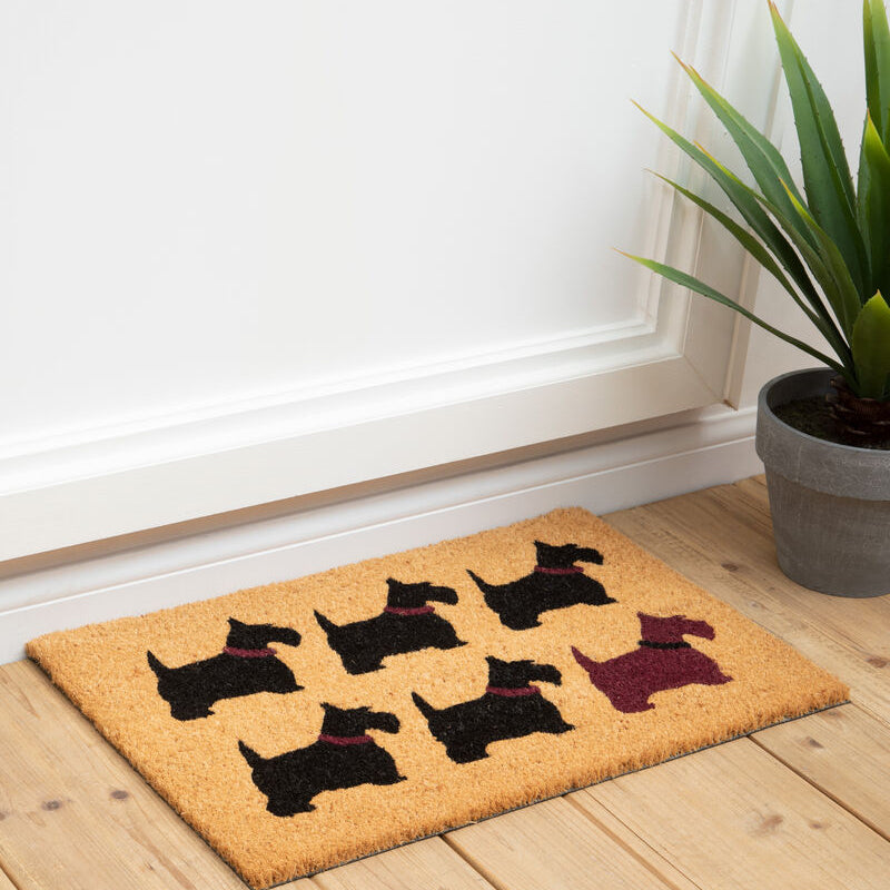 Doormat with dog design on a wooden floor next to a plant