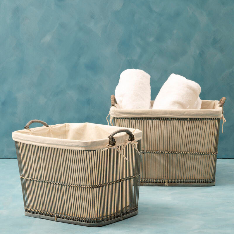 Two woven baskets with towels on a textured blue background