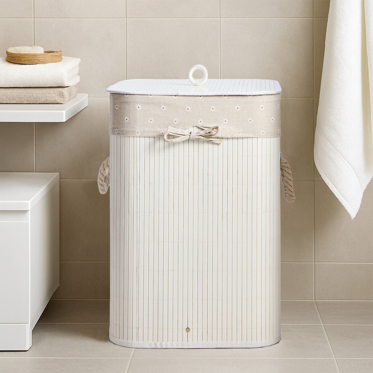 White laundry basket with decorative bow in a bathroom setting