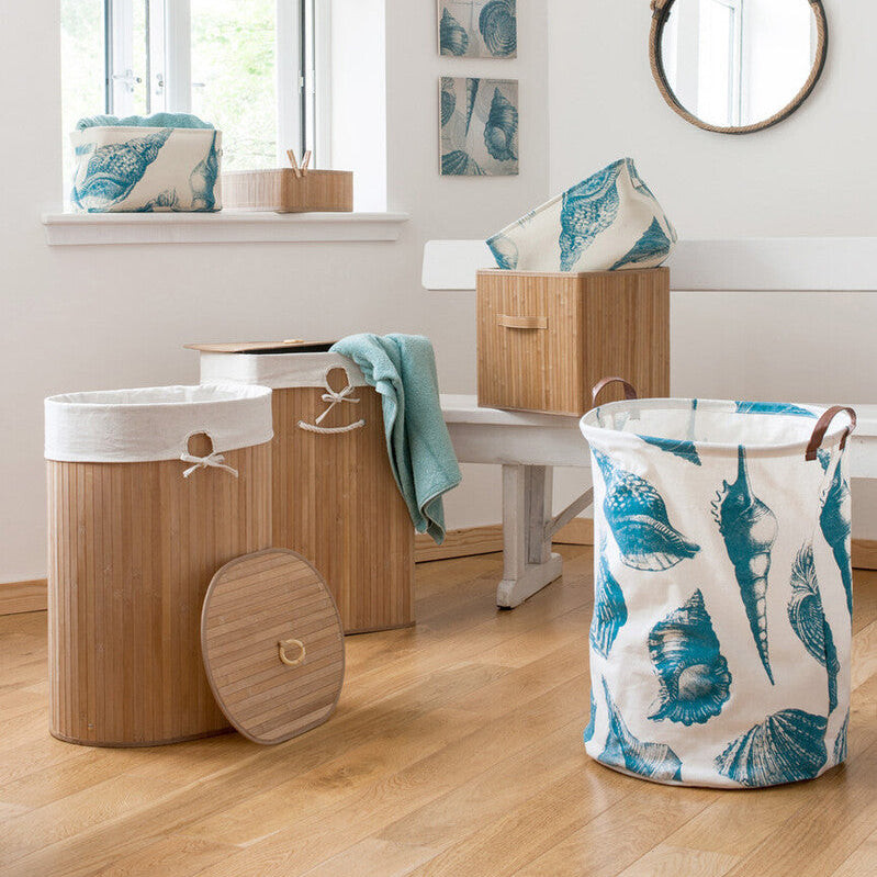 Laundry baskets with leaf pattern on a wooden floor in a room with a mirror and window.