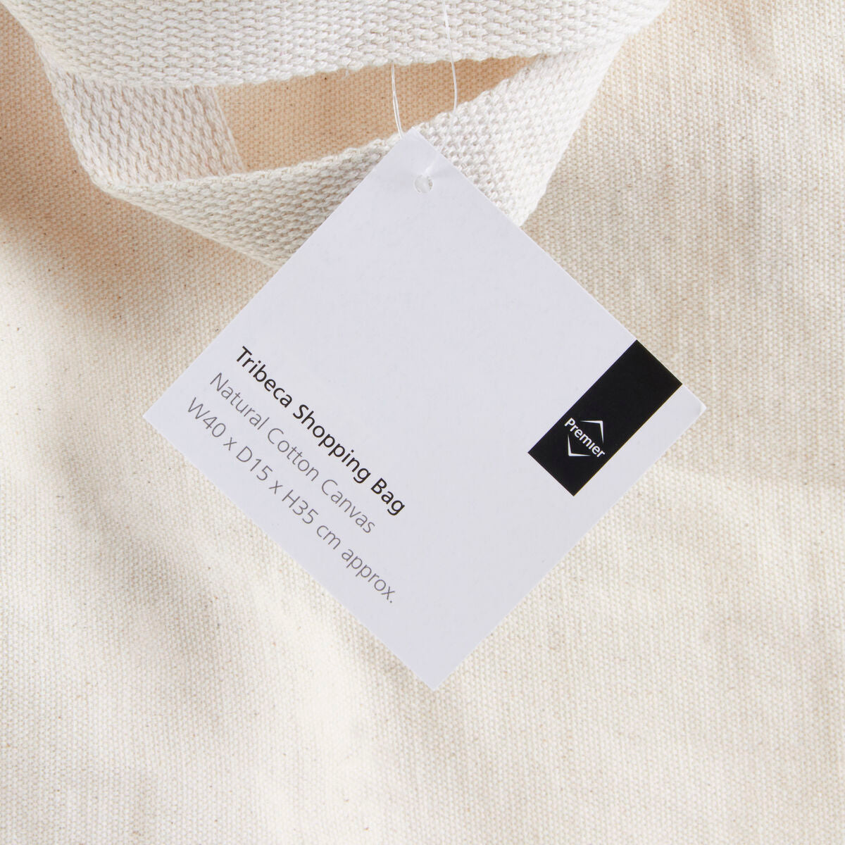 White Tribeca Shopping Bag label on a textured beige fabric background