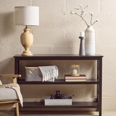 Wooden shelf with decorative items against a beige wall