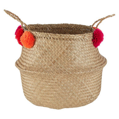Woven basket with colorful pom-poms on a white background
