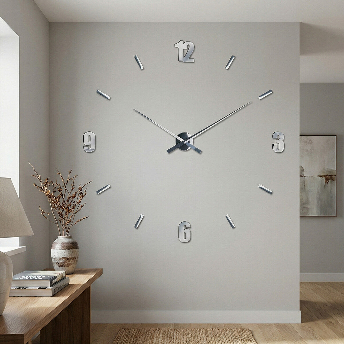 Large wall clock on a gray wall with a side table and lamp in the foreground.