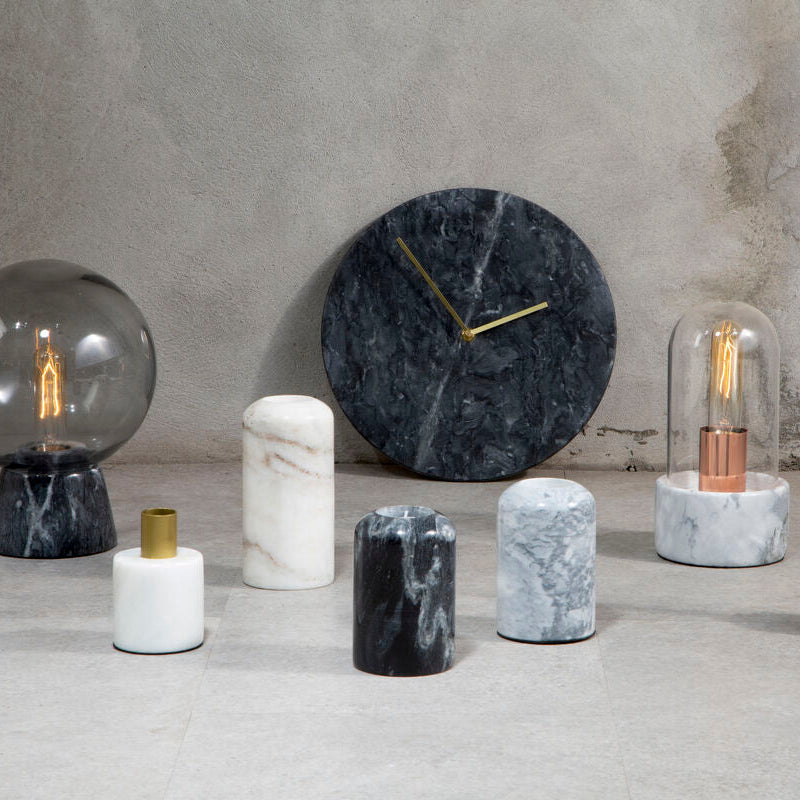 Decorative items including a clock, candles, and light bulbs on a neutral background