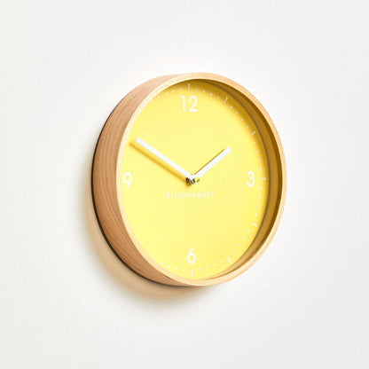 Yellow wall clock with wooden frame on a white background
