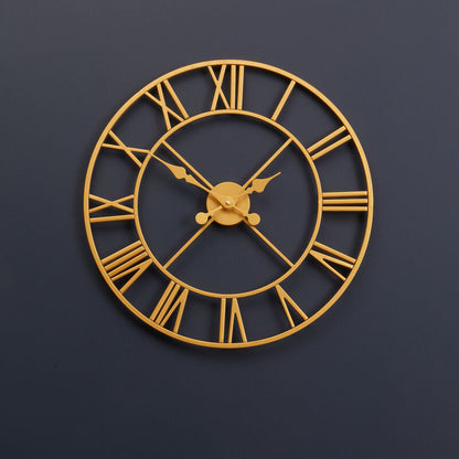 Gold wall clock with Roman numerals on a dark blue wall