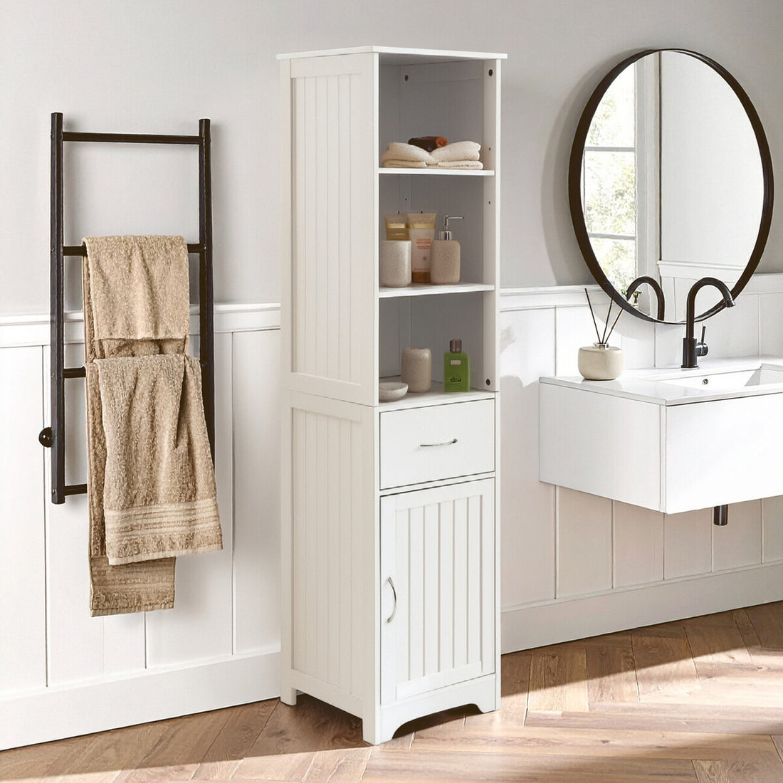 Bathroom with white tall cabinet, towel rack, and round mirror.