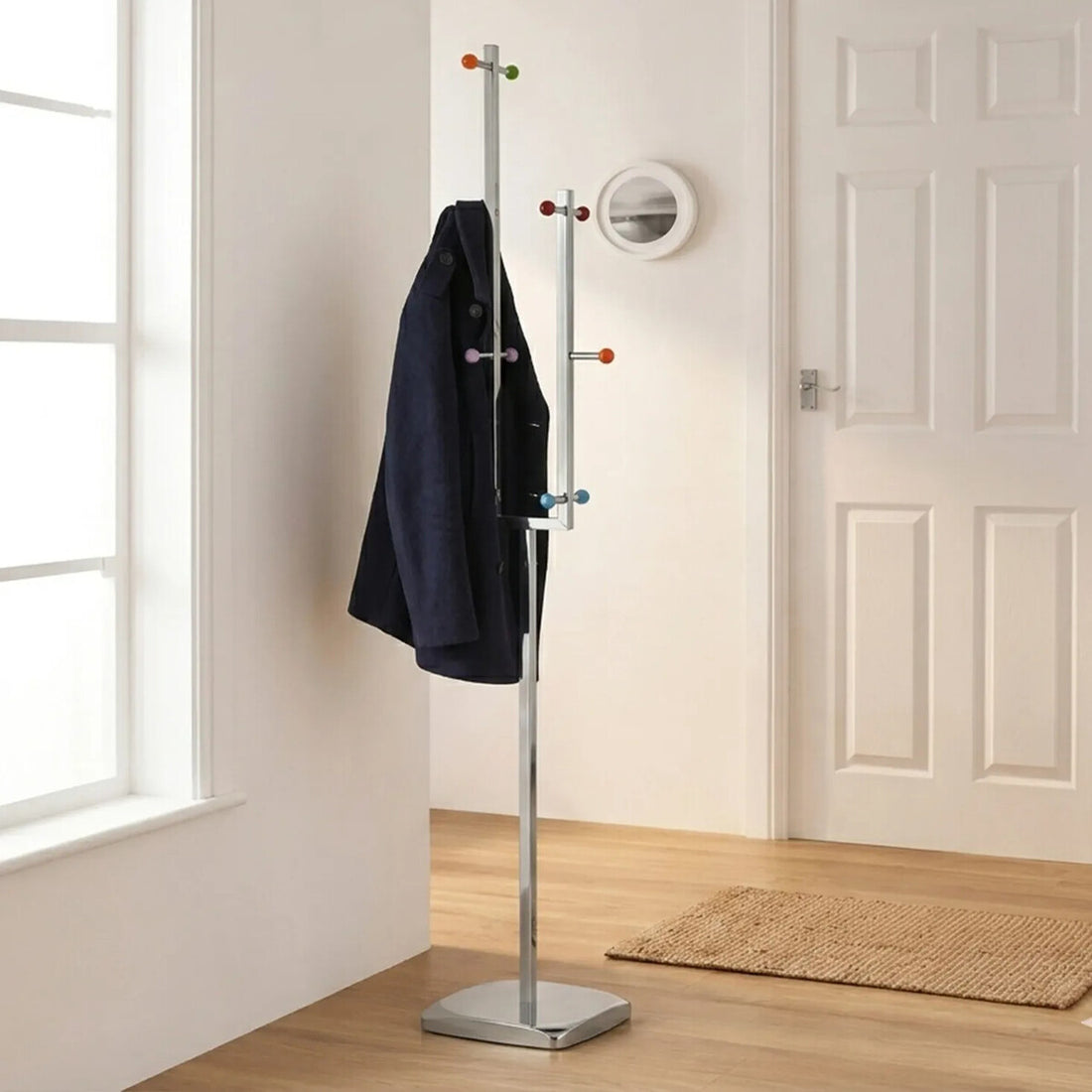 Coat stand with a black coat in a room with a window and door.