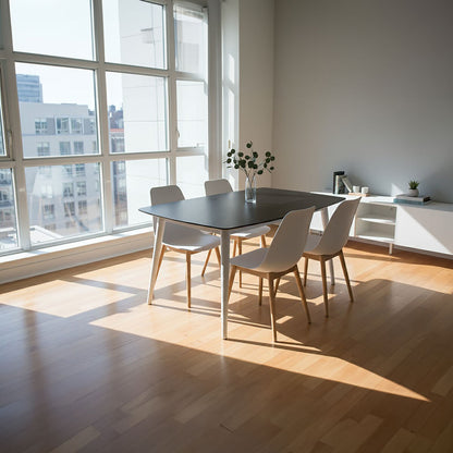 Modern dining area with a table and chairs near large windows in a well-lit room.