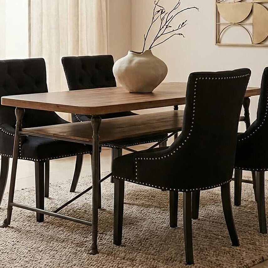 Dining room with wooden table and black chairs on a beige rug.