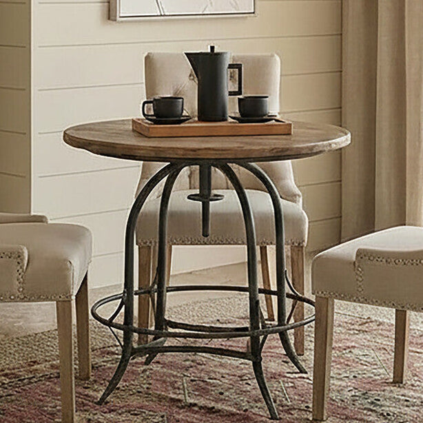 Dining room with a round wooden table and beige chairs on a patterned rug.