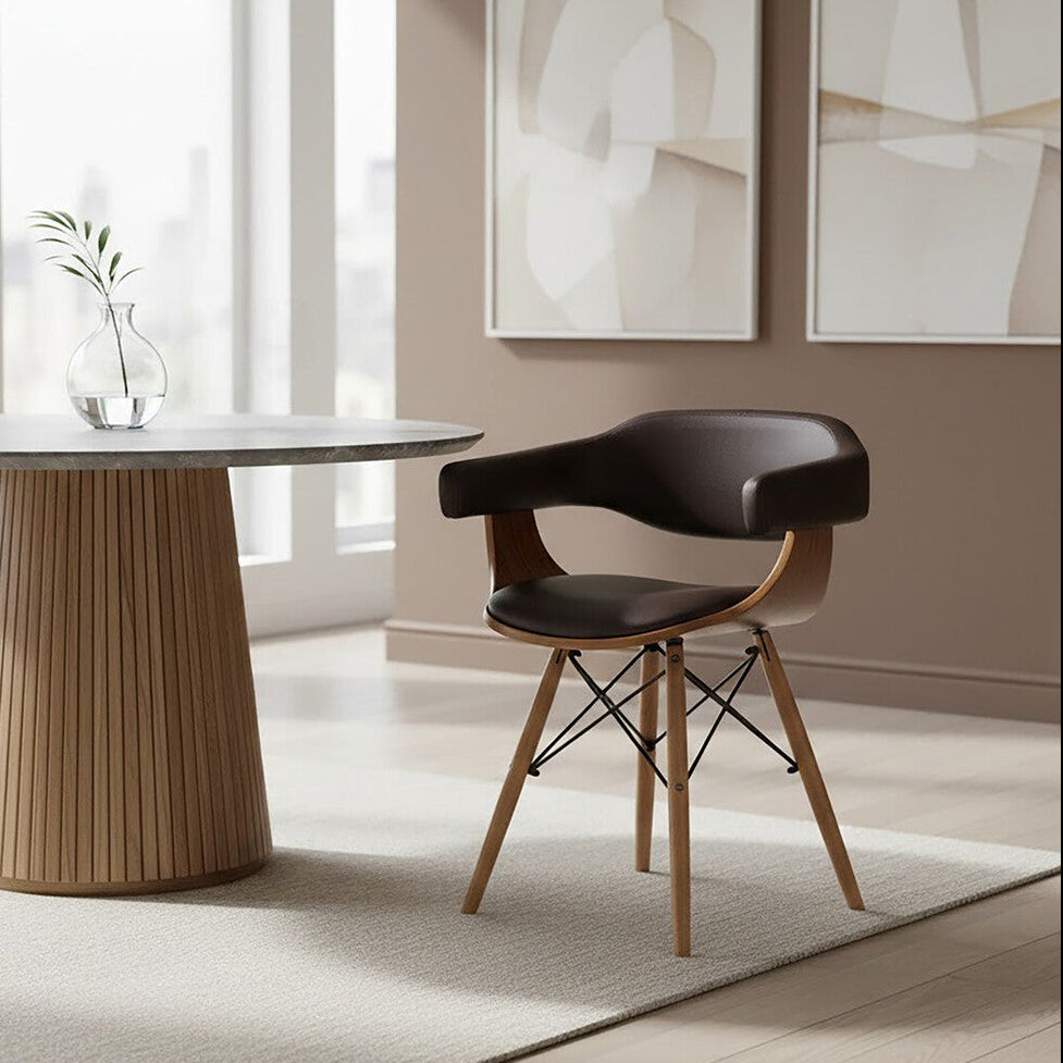 Modern dining room with a round table and chair, abstract art on the wall.