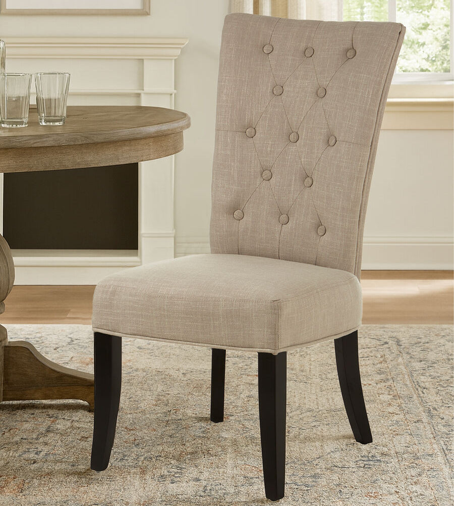 Beige upholstered chair with button tufting in a dining room setting.