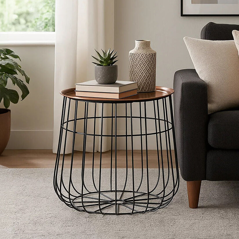 Modern living room with a dark sofa, wire side table, and decorative items.