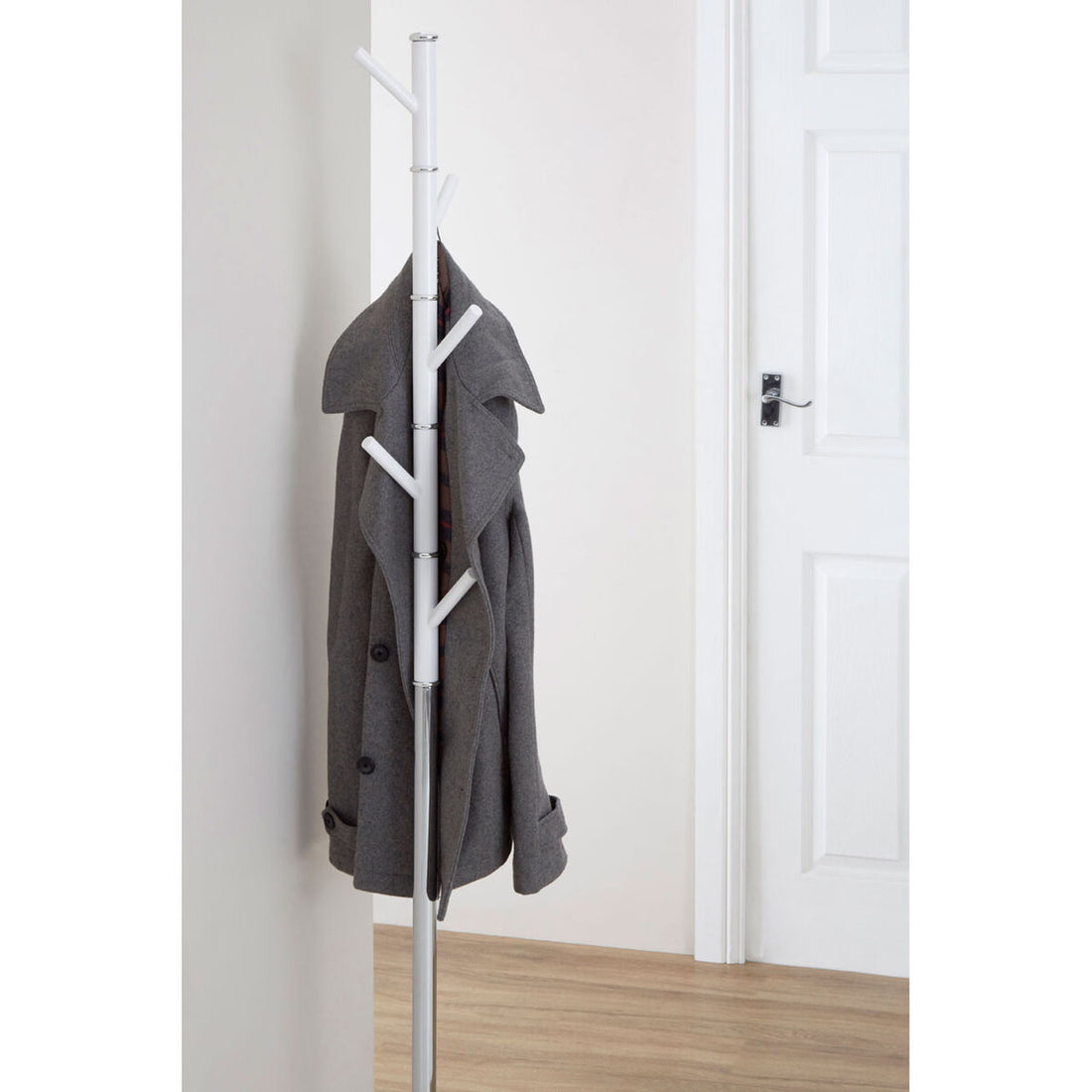 Gray coat hanging on a white coat rack against a white wall.