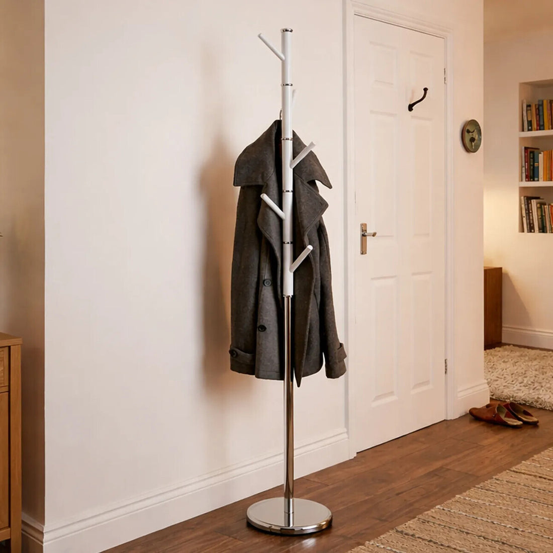 Coat rack with a gray coat against a white wall in a home setting.