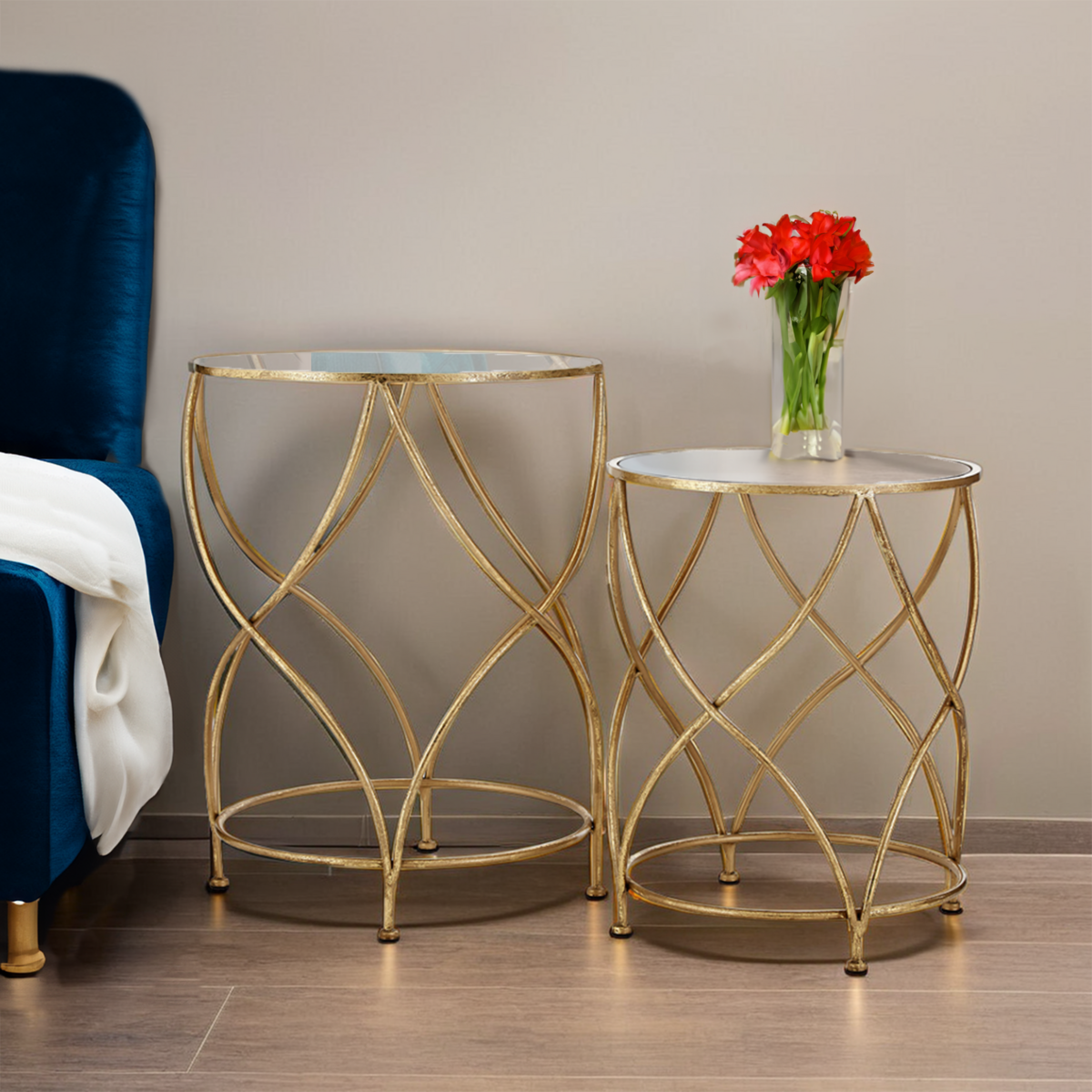 Two gold side tables with glass tops in a room setting.