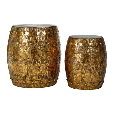 Two brass drums with decorative patterns on a white background