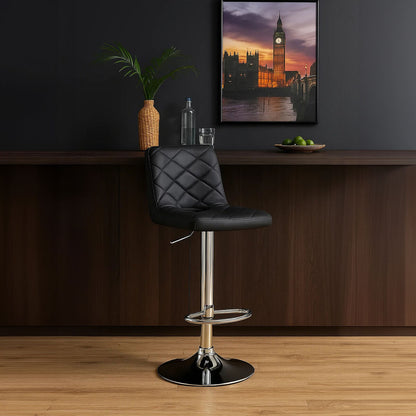Black bar stool in front of a wooden counter with decor items against a dark wall.