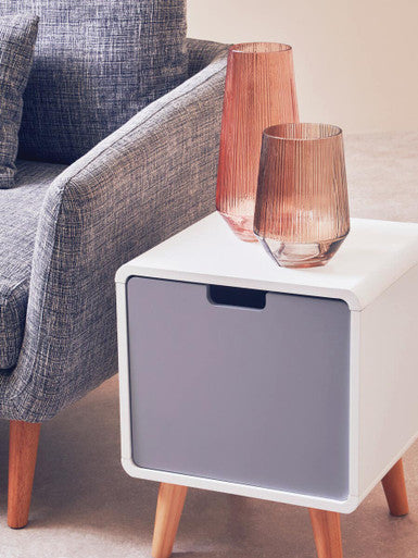 White side table with glass lampshades next to a gray sofa