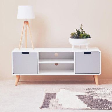 White entertainment console with wooden legs in a minimalistic living room setting.