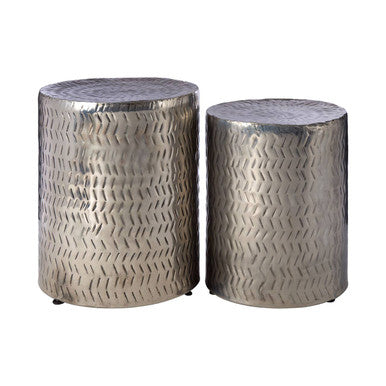 Two metallic silver stools with textured surface on a white background