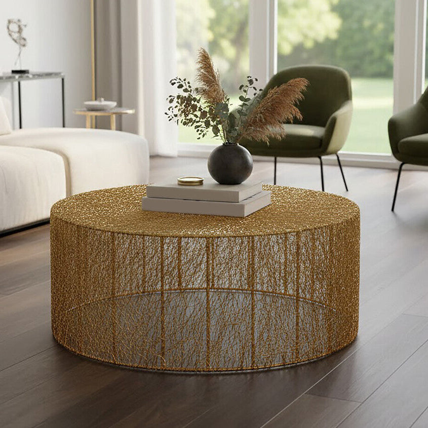 Round gold coffee table in a modern living room with chairs and decor.
