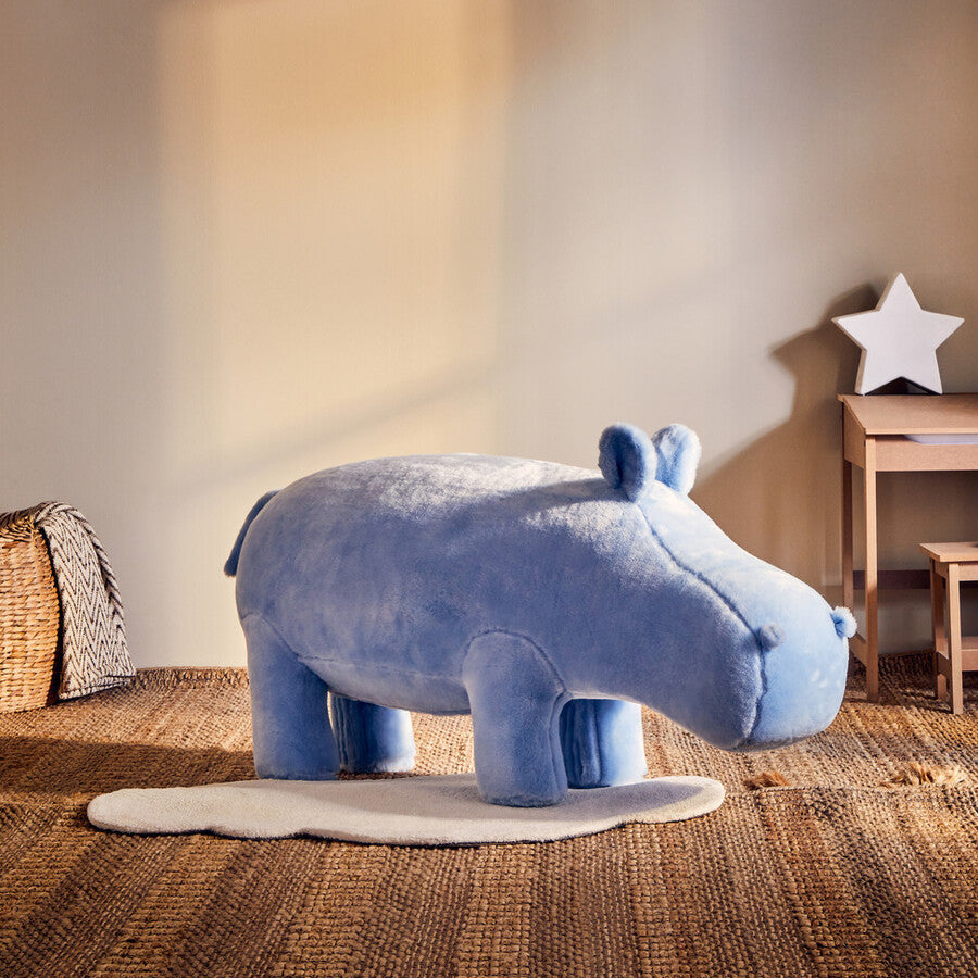 Blue hippo-shaped stool in a room with a star decoration on the wall.