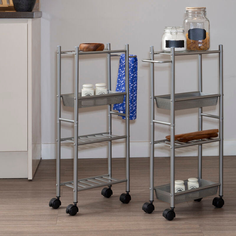 Two metal serving carts with wheels on a wooden floor against a gray wall.