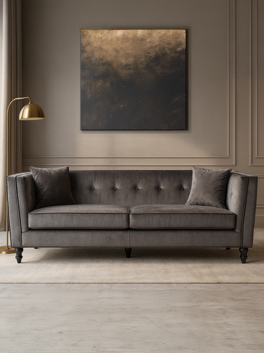 Gray sofa in a room with a gold lamp and abstract painting on the wall.