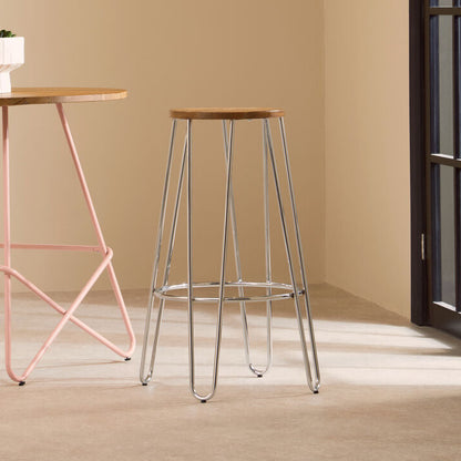Two bar stools with metal frames and wooden seats in a minimalistic room.