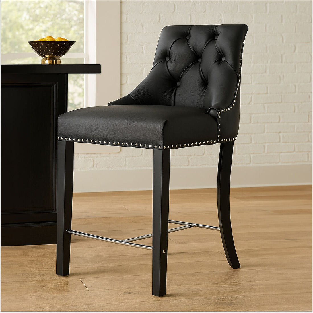 Black bar stool with tufted backrest and nailhead trim in a room setting.