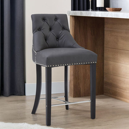 Gray bar stool with tufted backrest and nailhead trim in a room setting.