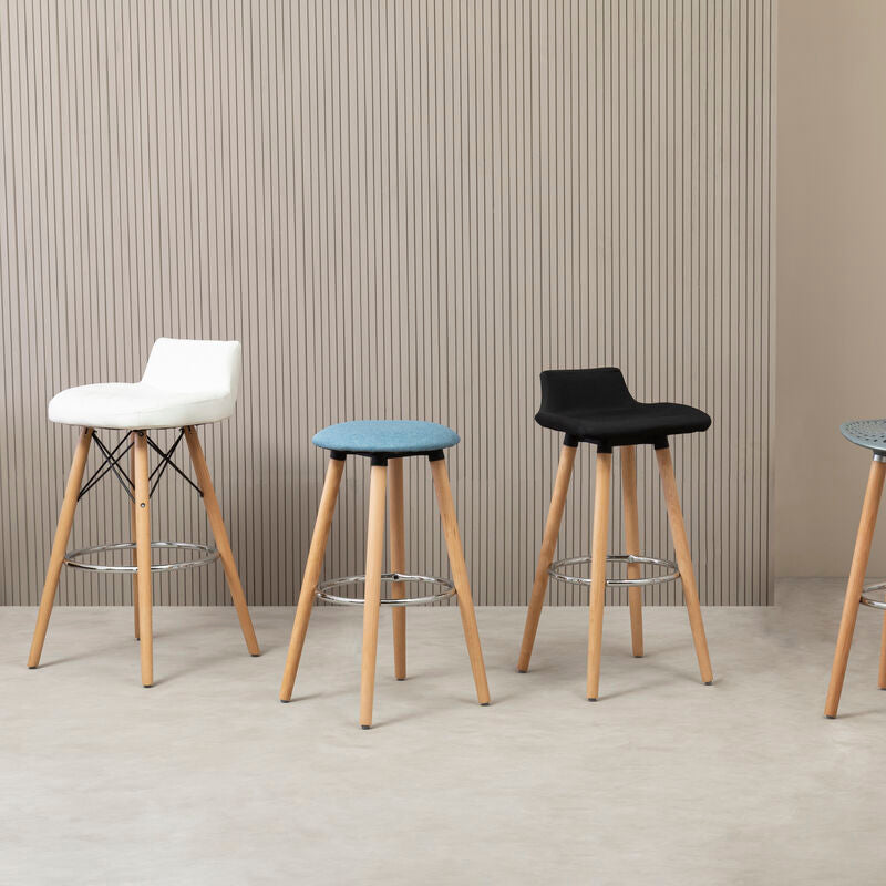 Four bar stools with different colored seats against a striped wall.