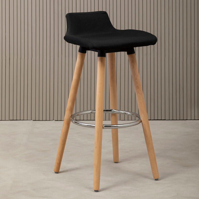 Black bar stool with wooden legs against a striped wall.