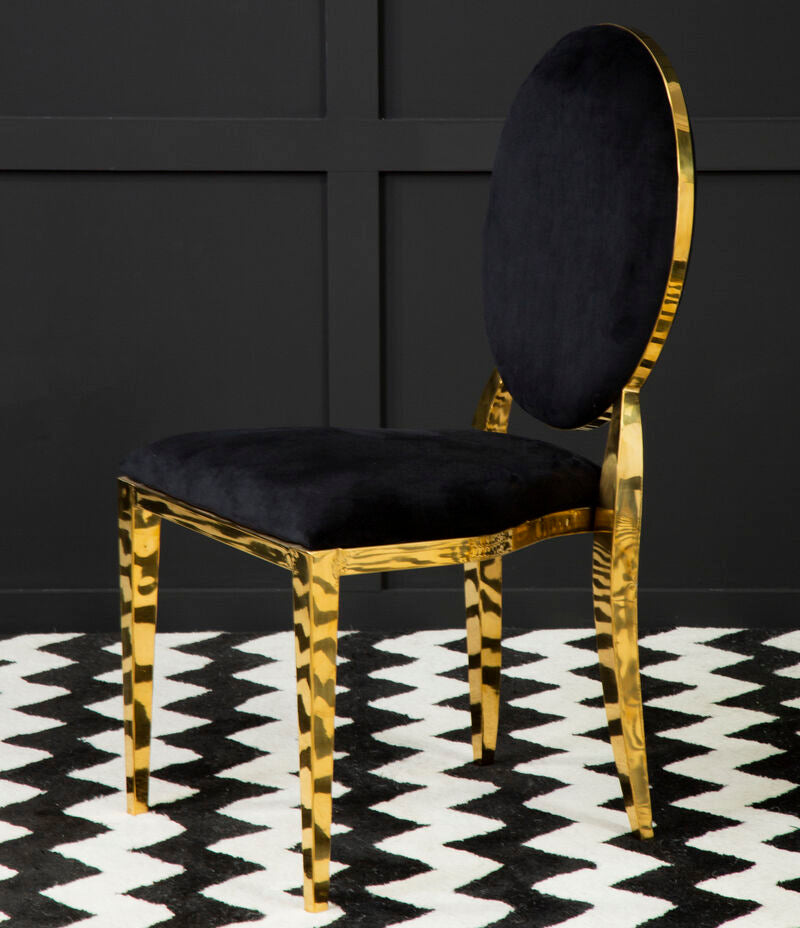 Chair with gold frame and black cushion on a black and white patterned rug
