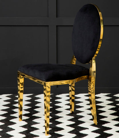 Chair with gold frame and black cushion on a black and white patterned rug