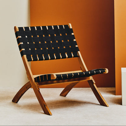 Wooden chair with black woven backrest against an orange wall