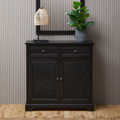 Black cabinet with a mirror, lamp, and plant against a striped wall.