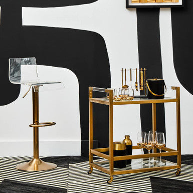 Modern bar cart with gold accents in a stylish room with abstract wall art.