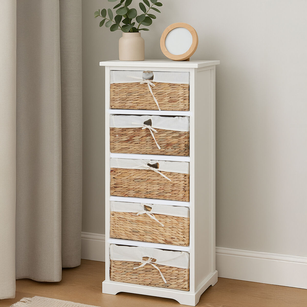 White cabinet with wicker drawers against a neutral wall