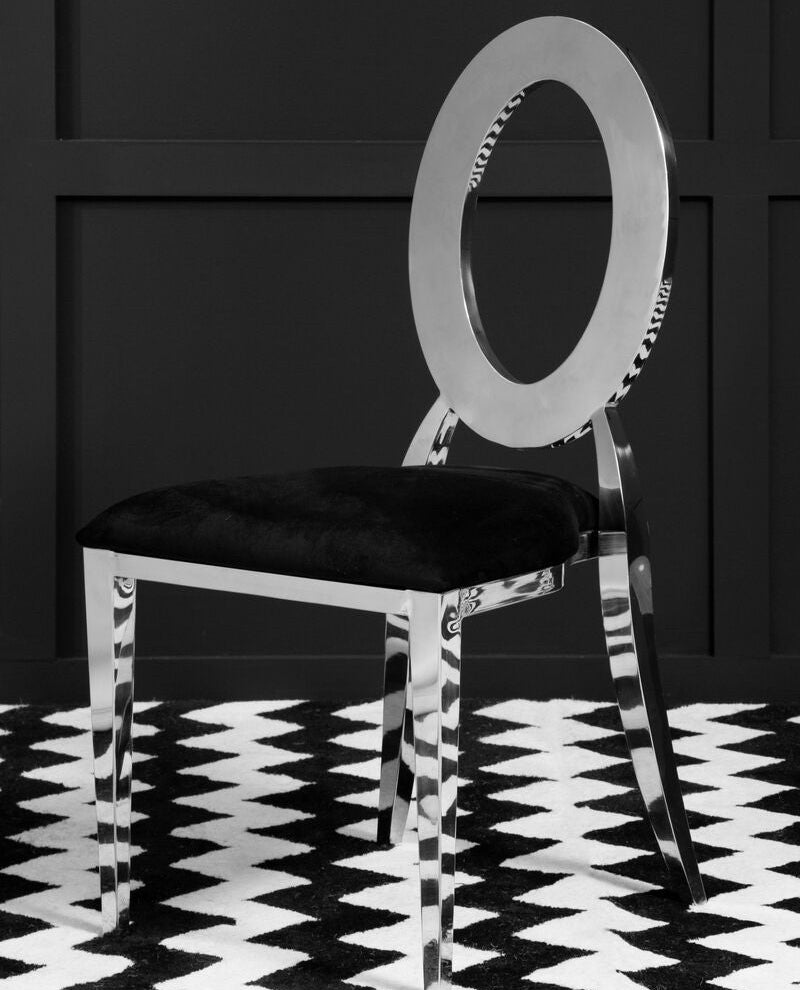 Chrome chair with a black cushion on a black and white patterned floor.