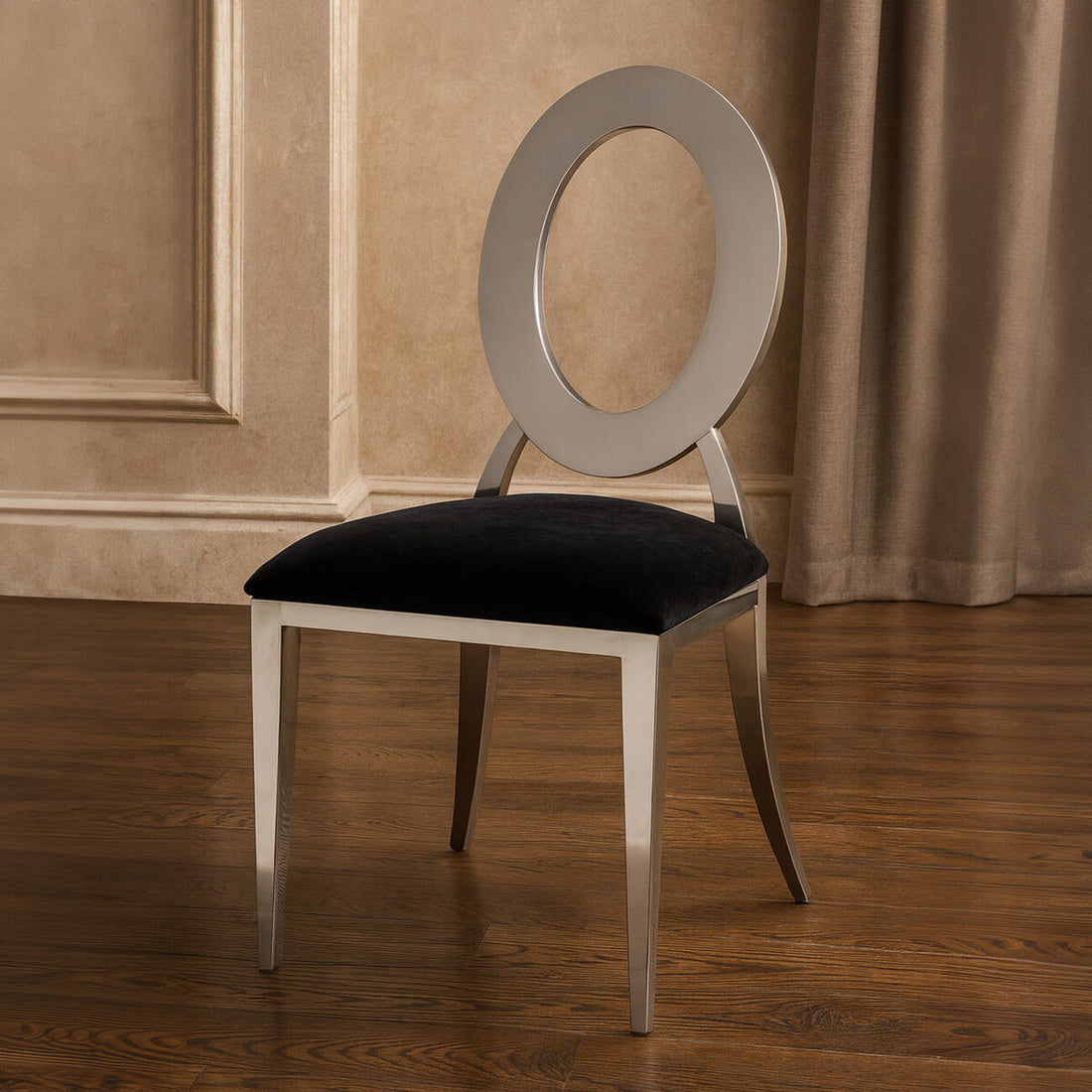 Chair with black cushioned seat and silver frame in a room with beige walls and wooden floor.